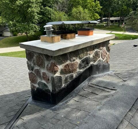 Stone planter on a paved driveway in a green residential area