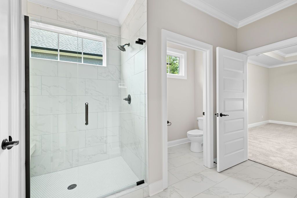 A bathroom with a walk in shower and a toilet.