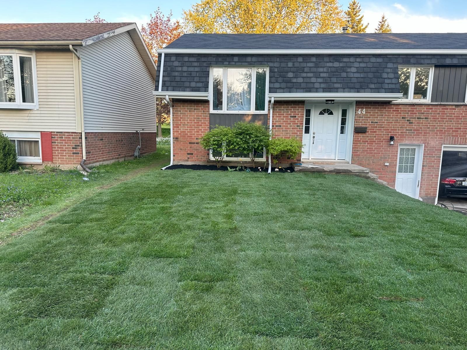 A house with a lush green lawn in front of it.