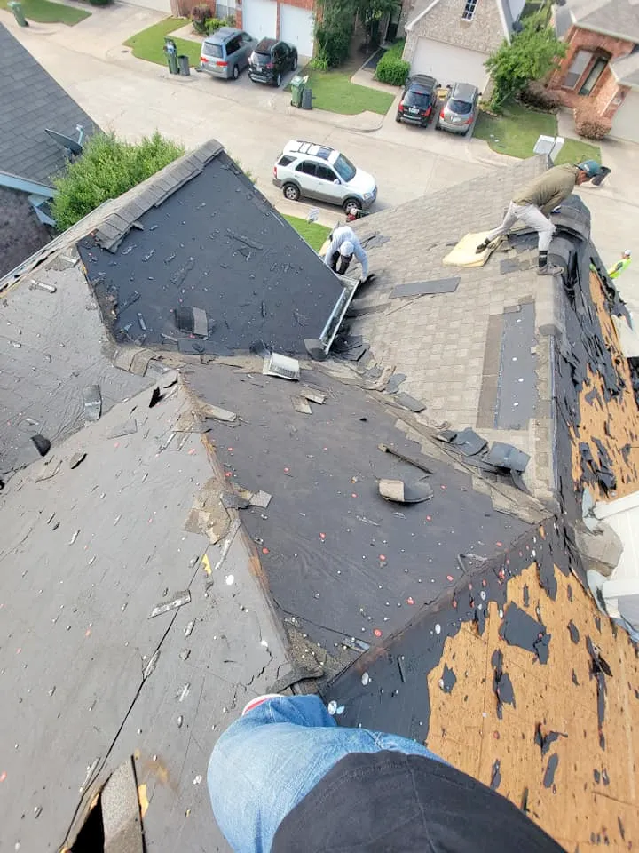 A person is standing on the roof of a house.