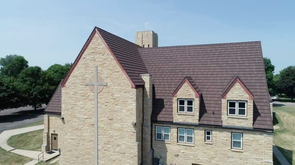 An aerial view of a church with a cross on the roof.