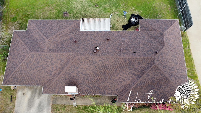 An aerial view of a house with a roof that is being repaired.