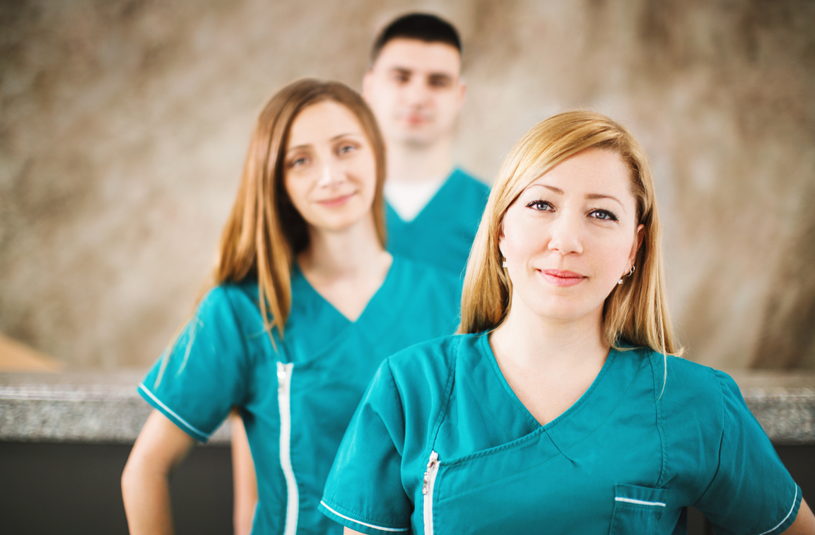 A group of nurses in scrubs are posing for a picture.