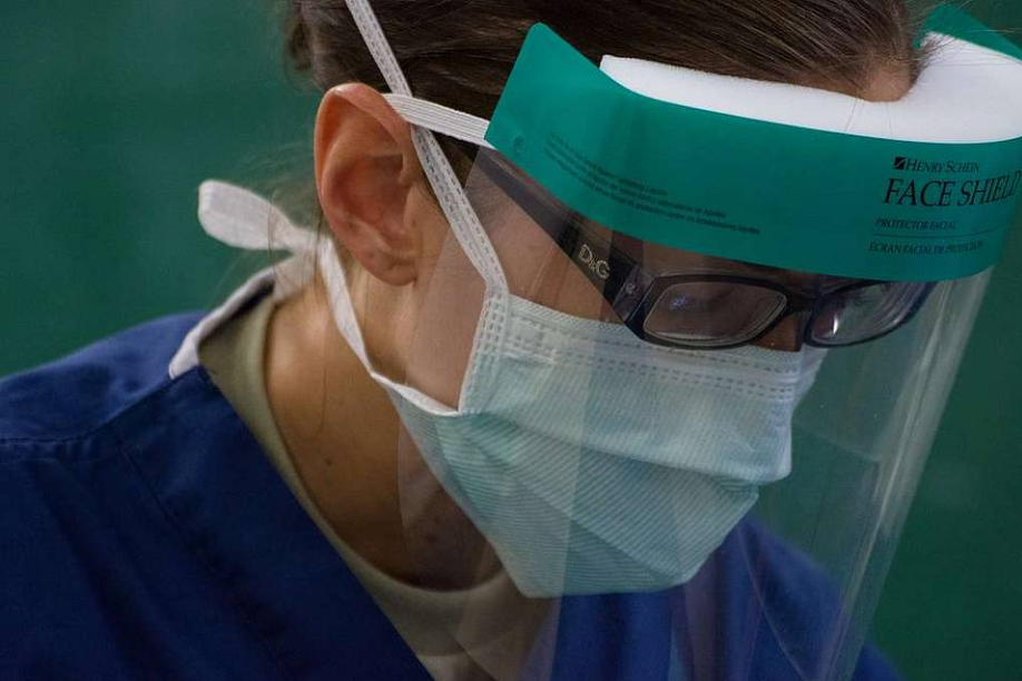 A woman wearing a mask and a face shield.