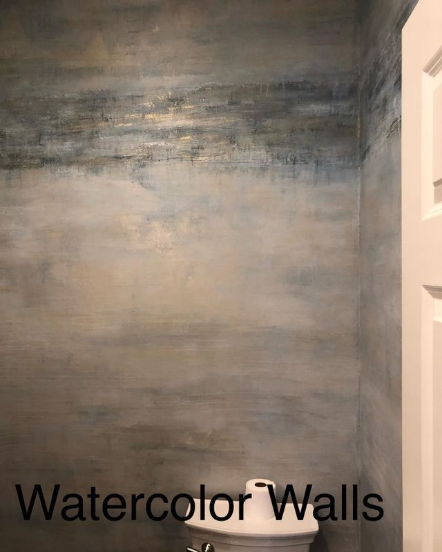 Watercolor walls in a small bathroom, featuring shades of blue, gold, and beige.