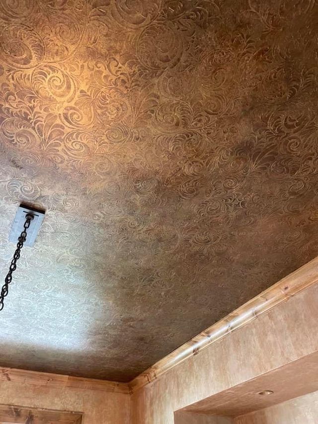 Textured brown ceiling with ornate pattern. Wooden trim. Light fixture partially visible.
