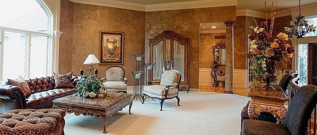 Luxurious living room with brown walls, leather furniture, and ornate details.