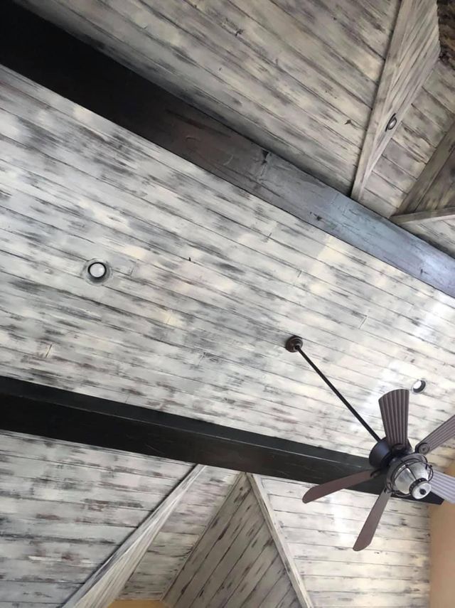 Wood ceiling with gray wash finish and dark beams, ceiling fan.