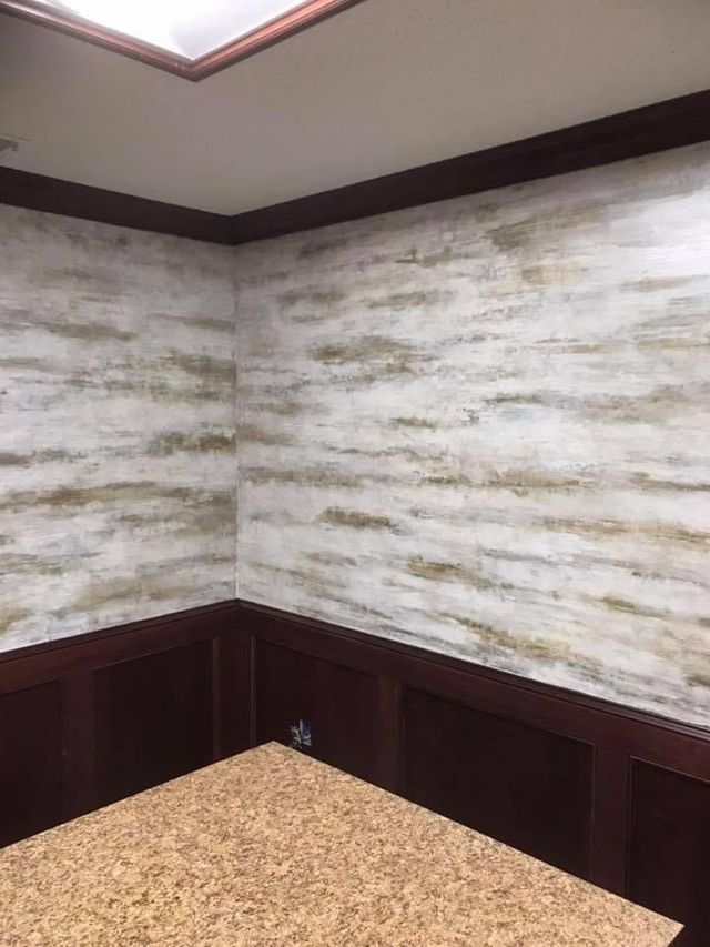 Interior office corner with textured white and gold walls, dark wood trim and wainscoting.