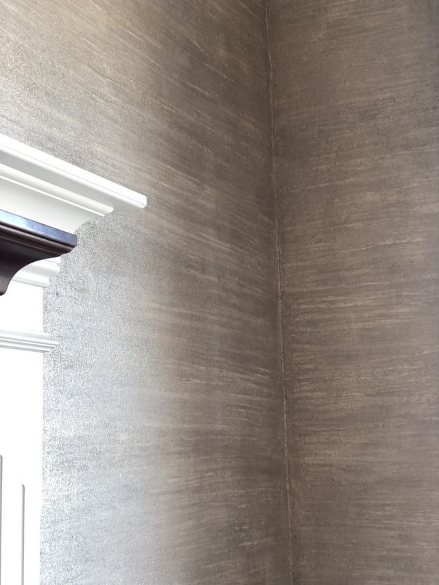 Textured gray wall with a white window frame in the corner.