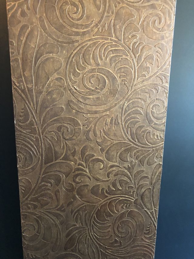 Textured panel with swirling, floral pattern in shades of brown and gold.