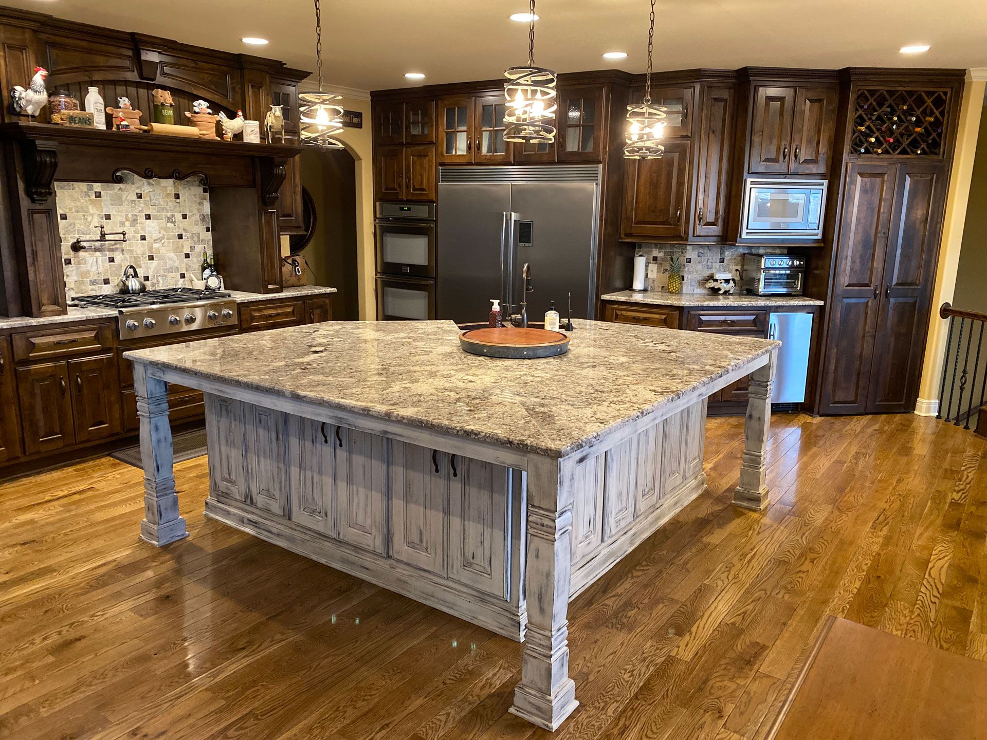 Spacious kitchen with dark wood cabinets, granite island, and hardwood floors