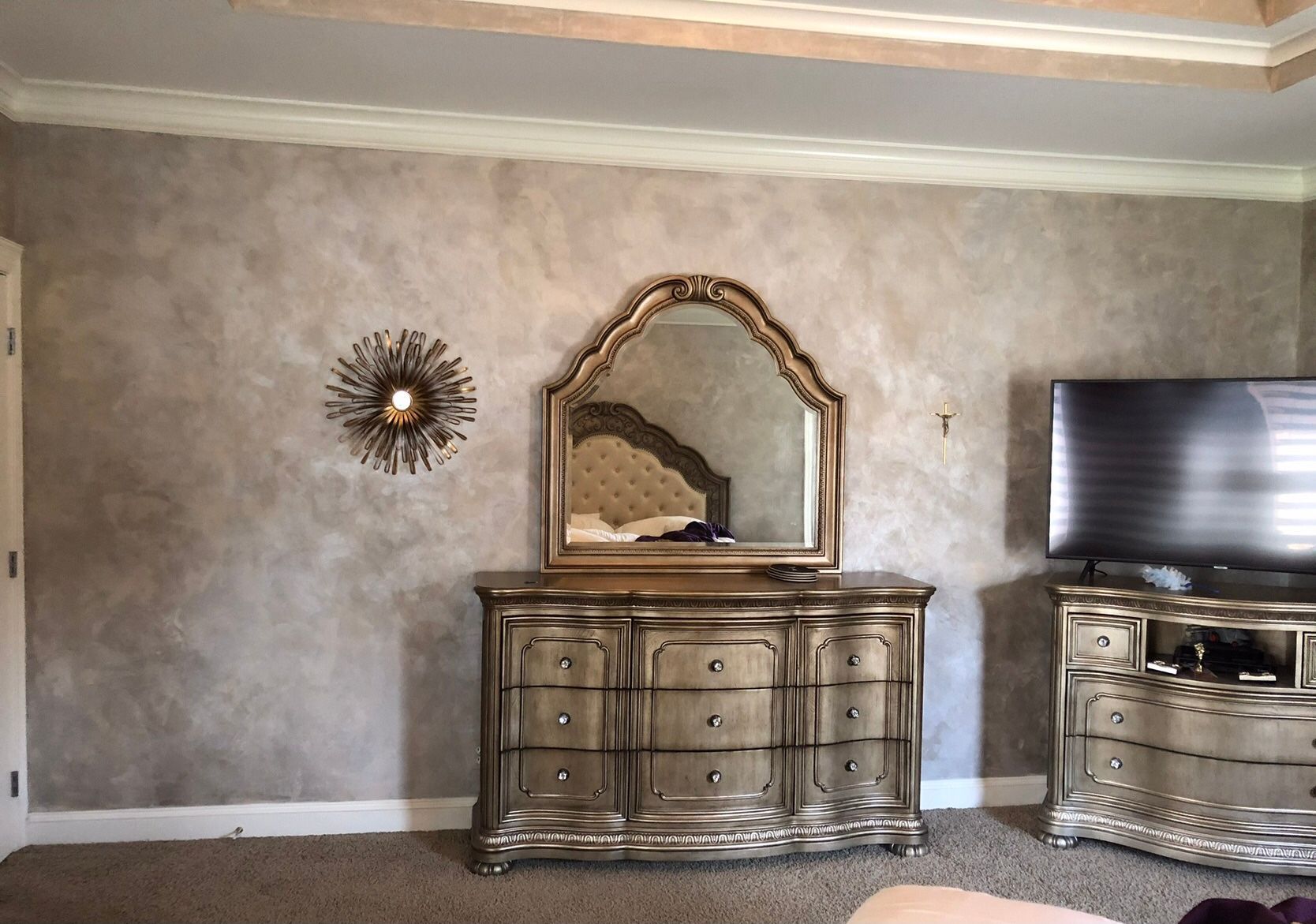 Elegant living room with silver dresser, ornate mirror, wall decor, and a TV on the right