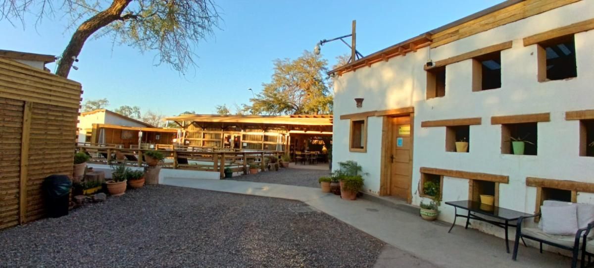 Un gran edificio blanco con muchas ventanas y un patio al frente.