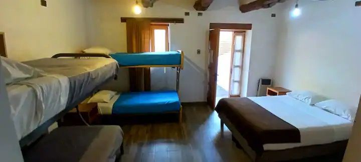 Un dormitorio con una litera, una cama y un sofá.