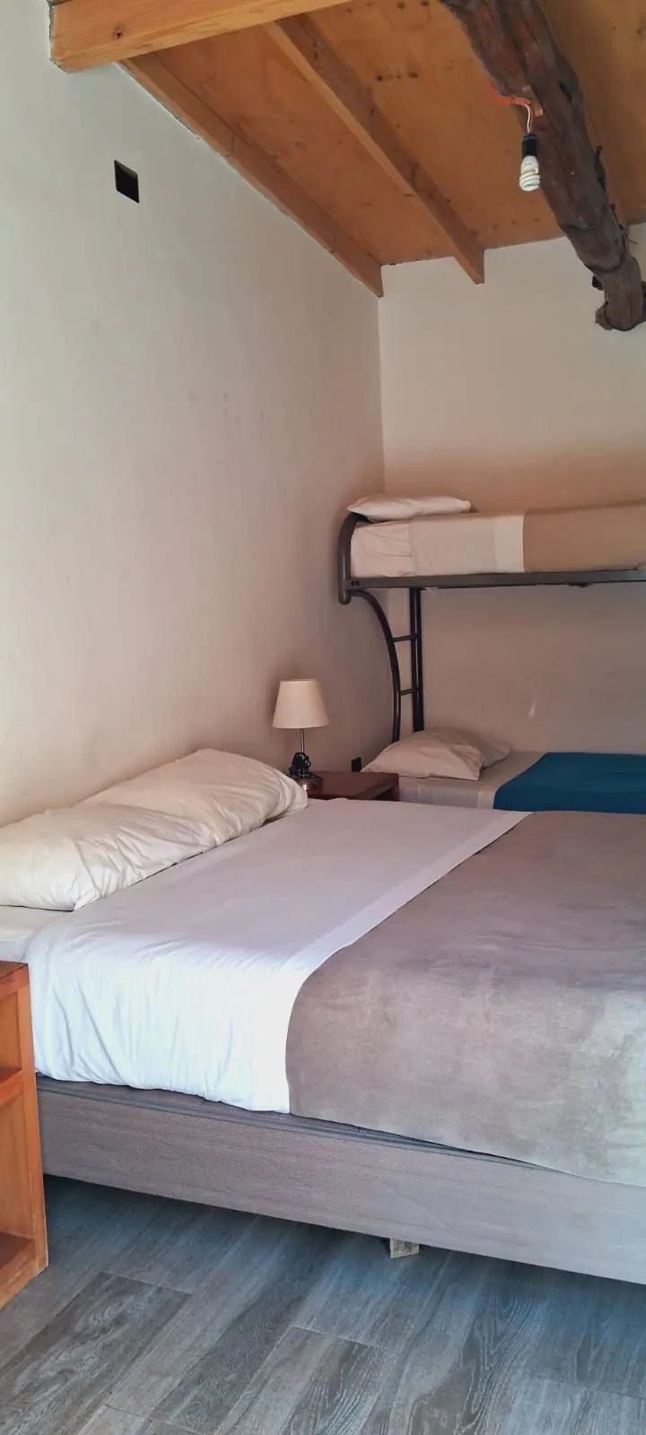 Un dormitorio con una cama king size y una litera.
