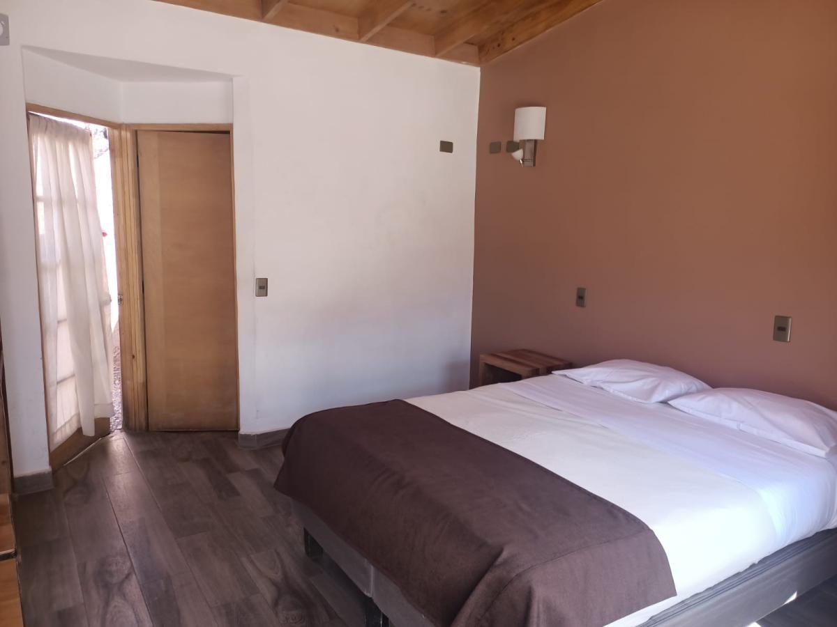 Un dormitorio con una cama y una lámpara en la pared.
