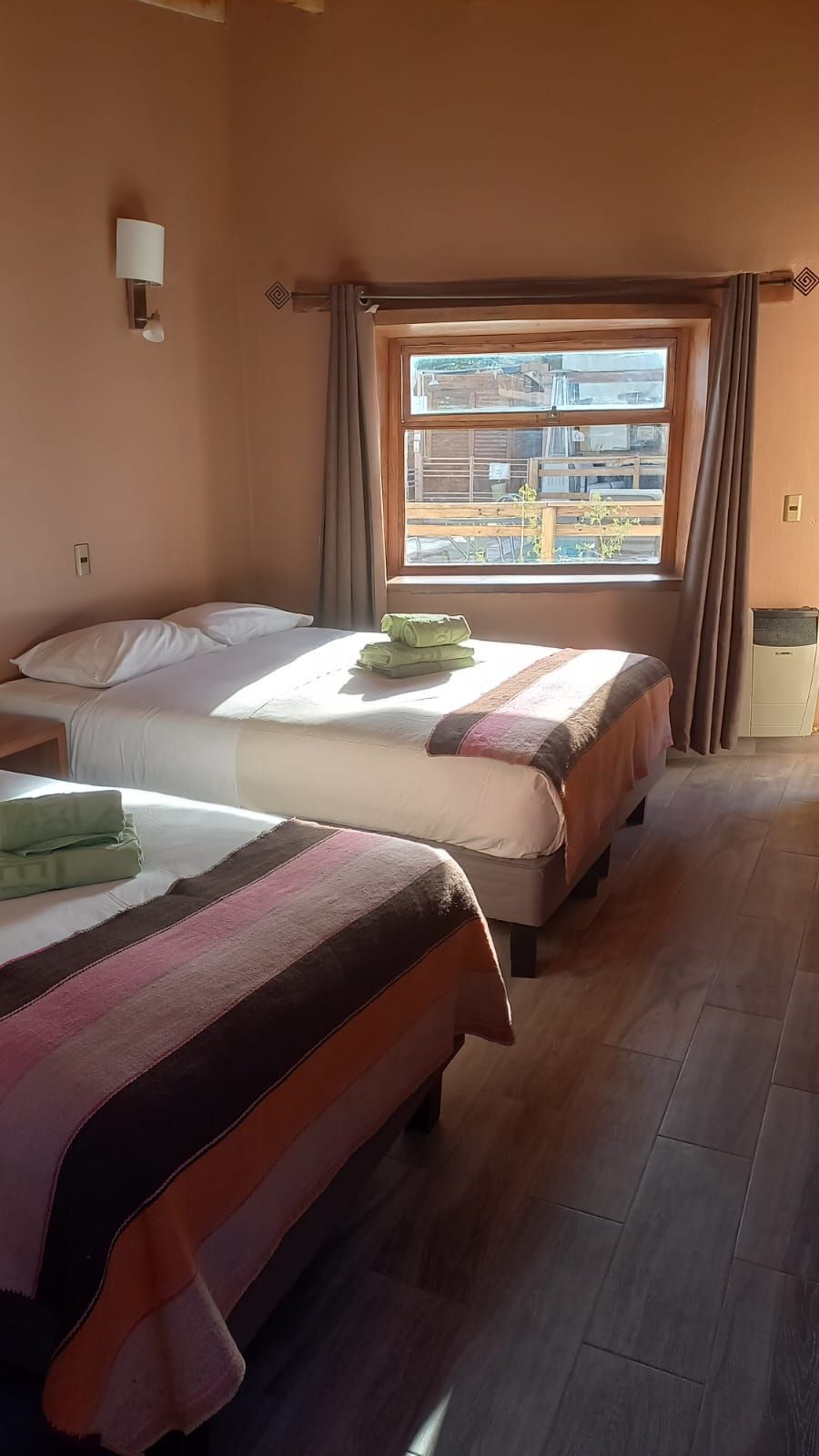 Una habitación de hotel con dos camas y una ventana.
