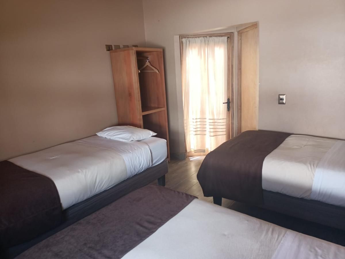 Una habitación de hotel con dos camas y una puerta.