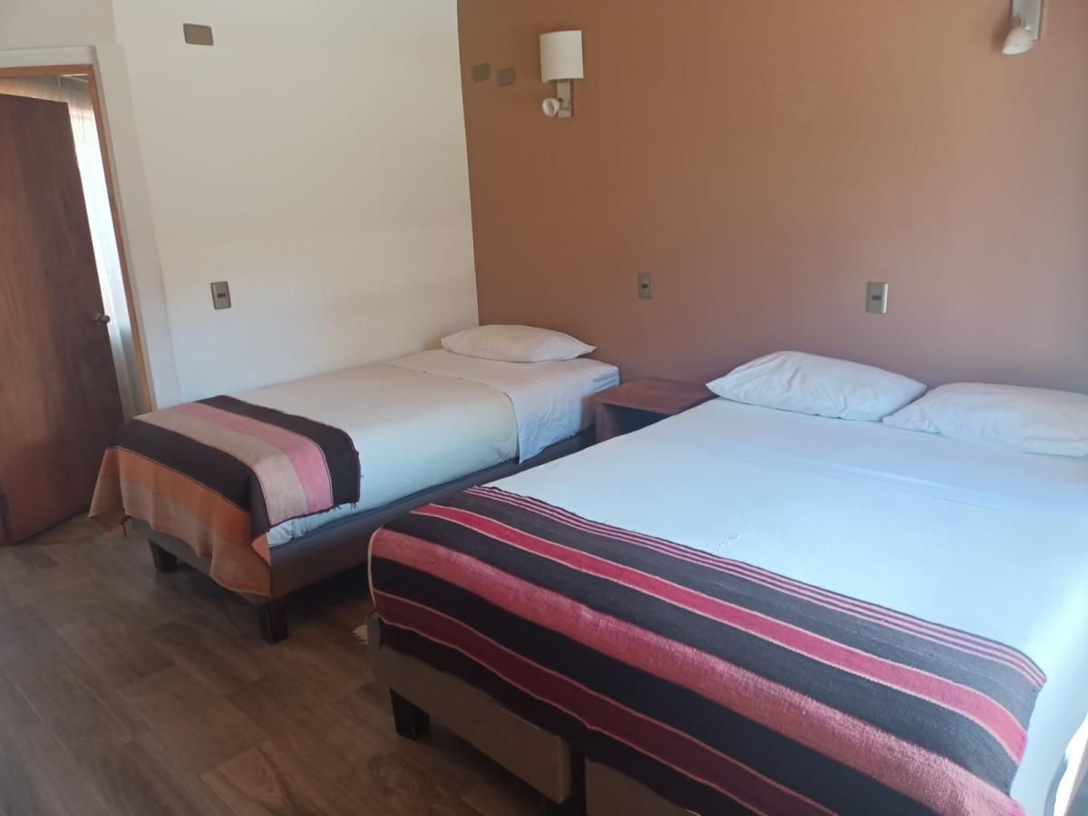 Una habitación de hotel con dos camas y una mesita de noche.