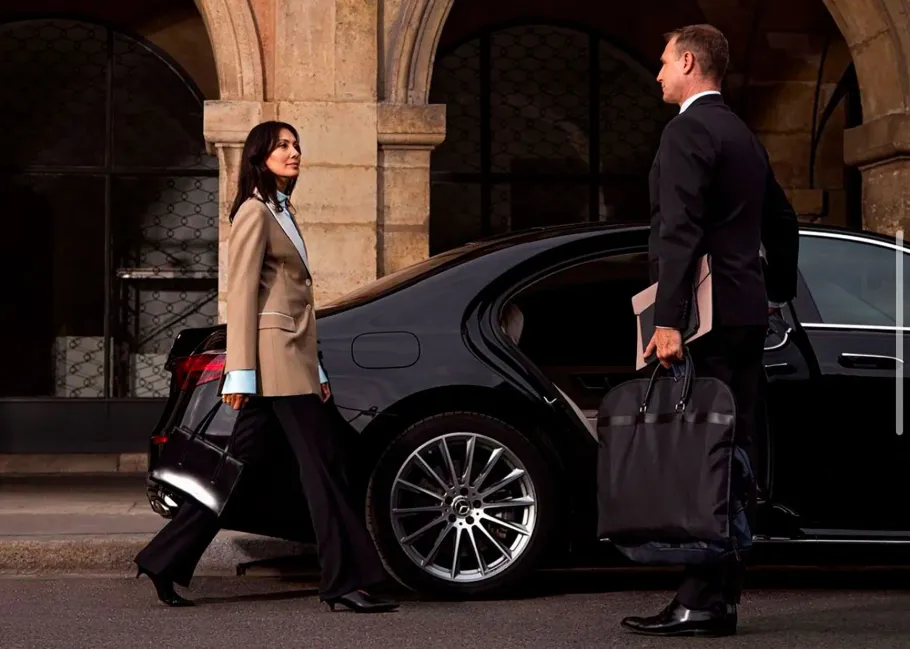 A man and a woman are standing next to a car.