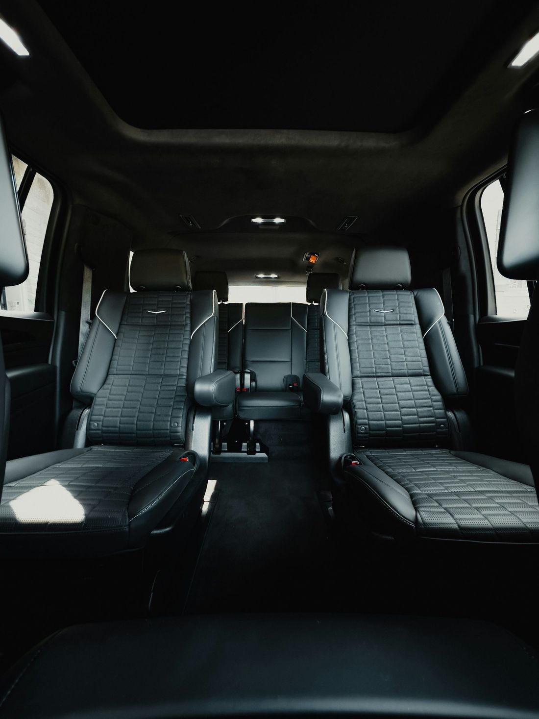 The inside of a car with a lot of seats and a sunroof.