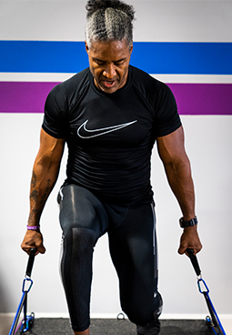 A man is doing exercises with resistance bands in a gym.