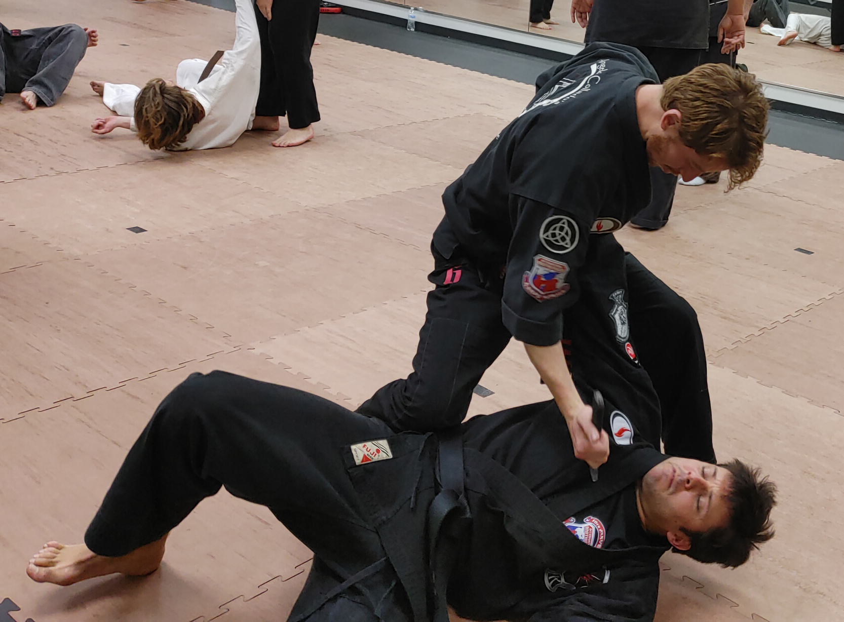 A group of people are practicing martial arts on a mat