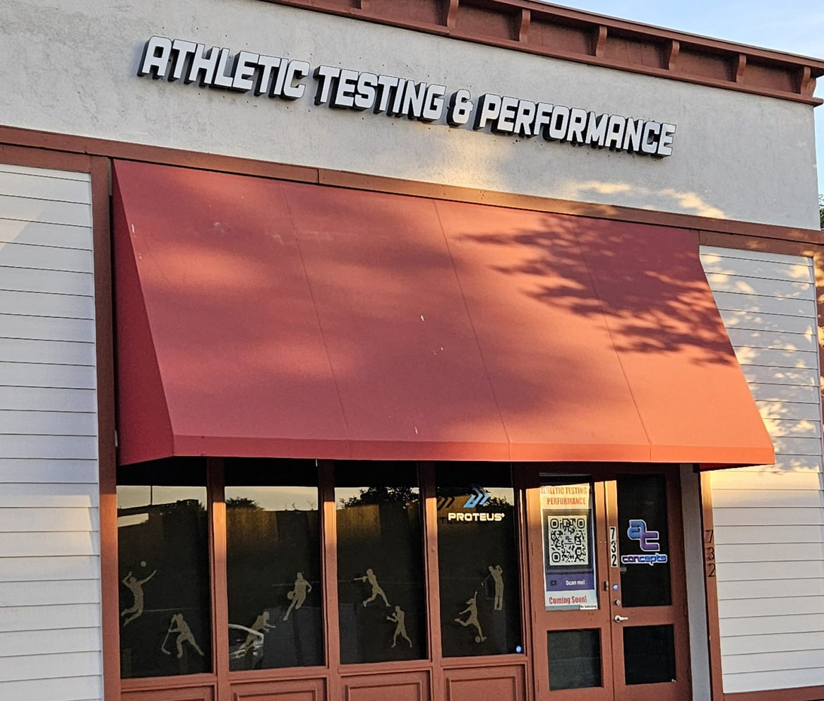 A large gym with a lot of equipment and a purple wall.
