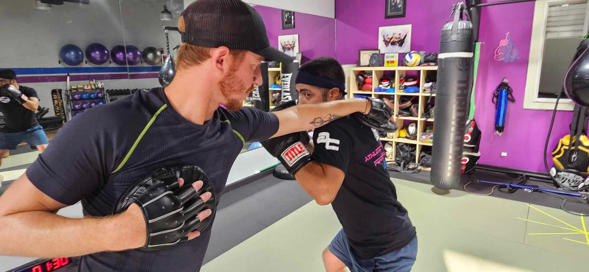 Two men are practicing martial arts in a gym.