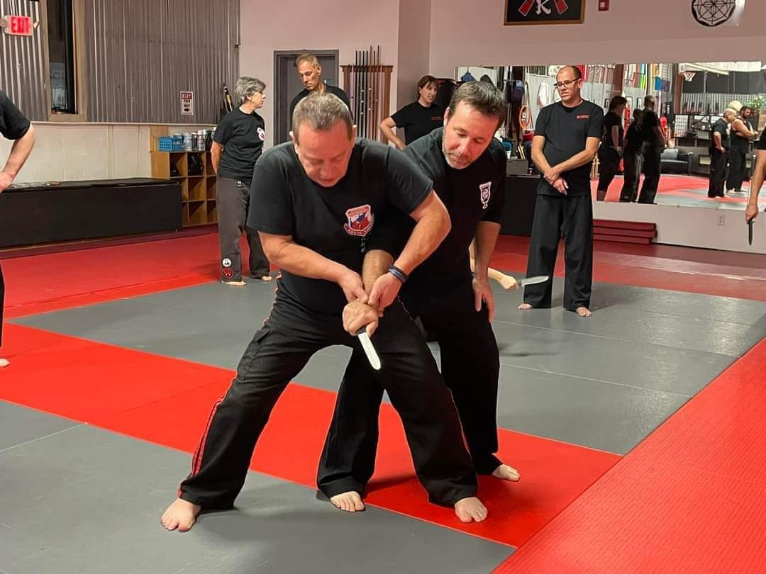 A group of men are practicing martial arts in a gym.