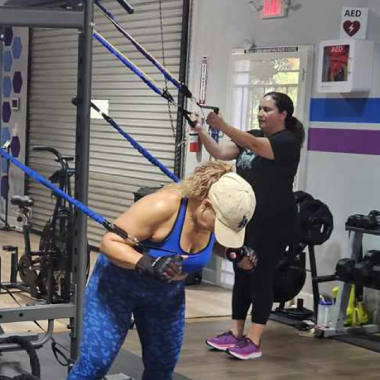 Two women are doing exercises in a gym.