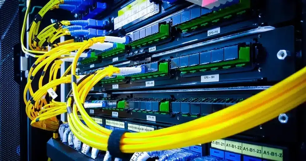 Server rack with yellow cables, blue ports, and green connectors.