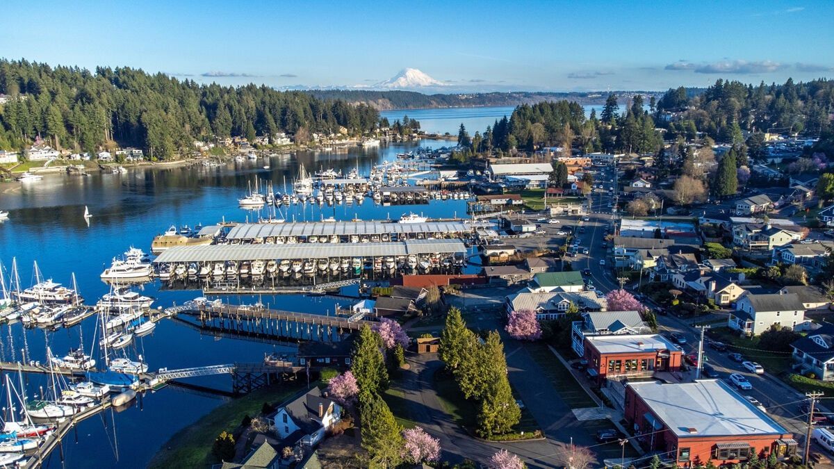 Aerial view of Gig Harbor waterfront with boats and Mount Rainier in the background.