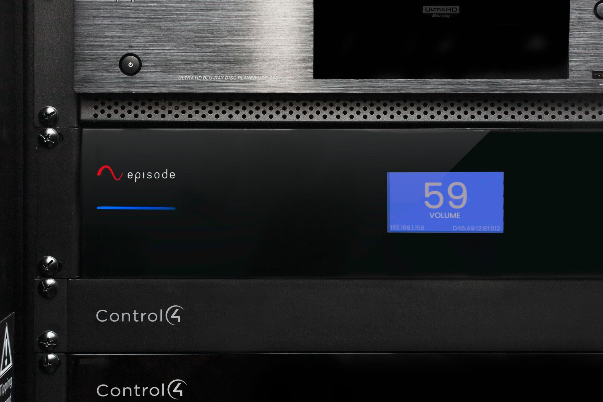 Black audio component in rack with a blue display showing 