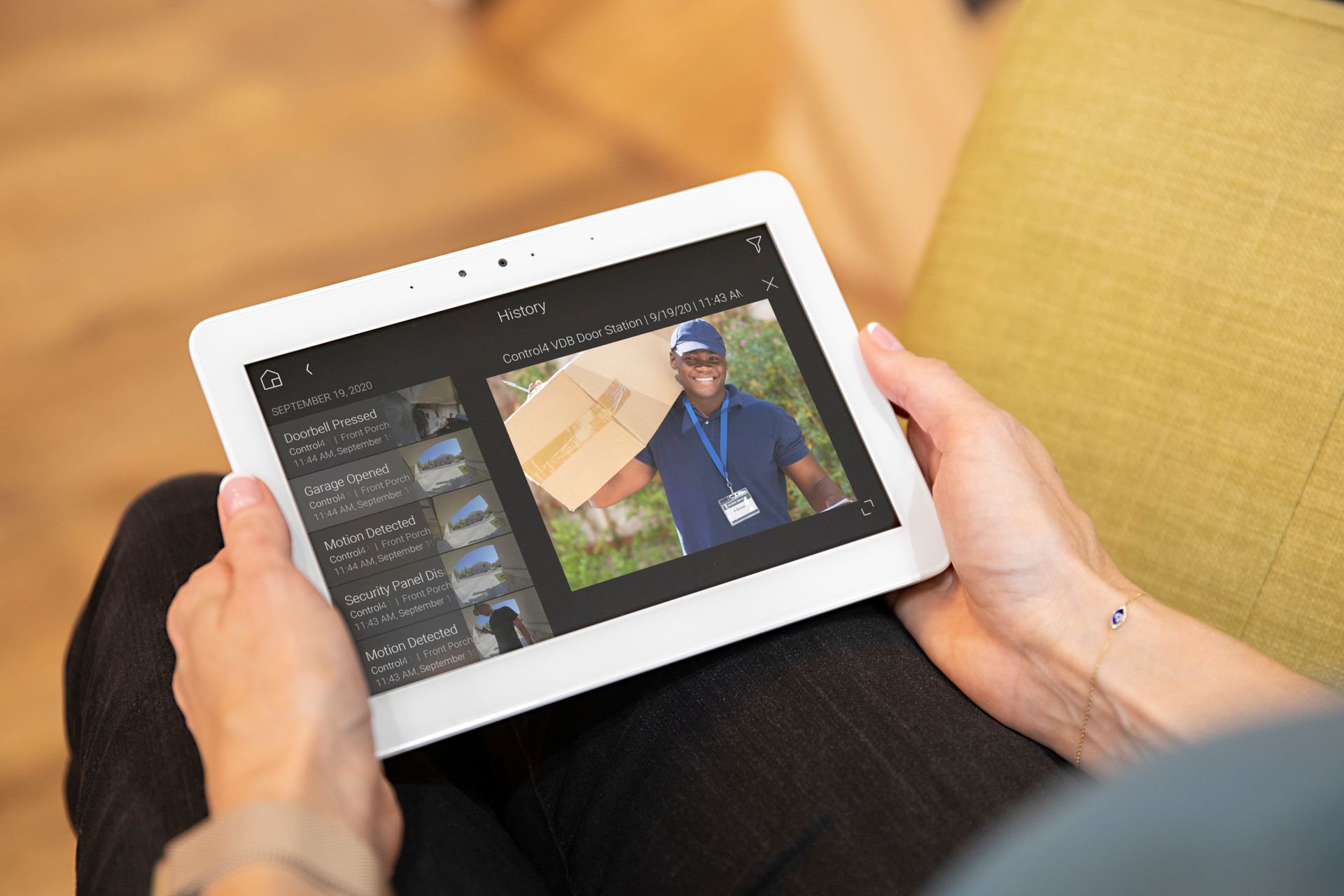Person holding a tablet showing a delivery person holding a package.