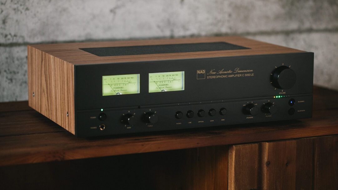NAD C 3050 LE stereophonic amplifier with wood side panels sitting on a wooden shelf.