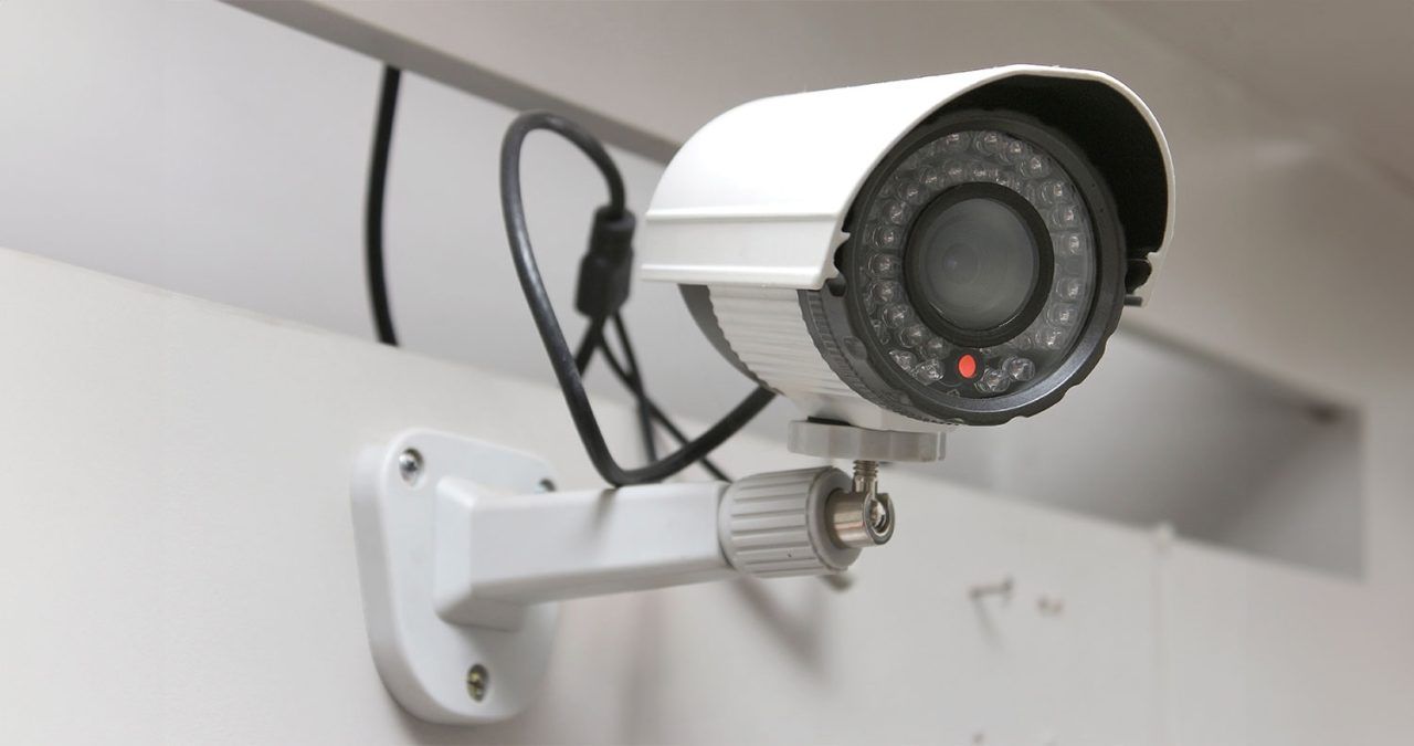 White security camera mounted on a wall.