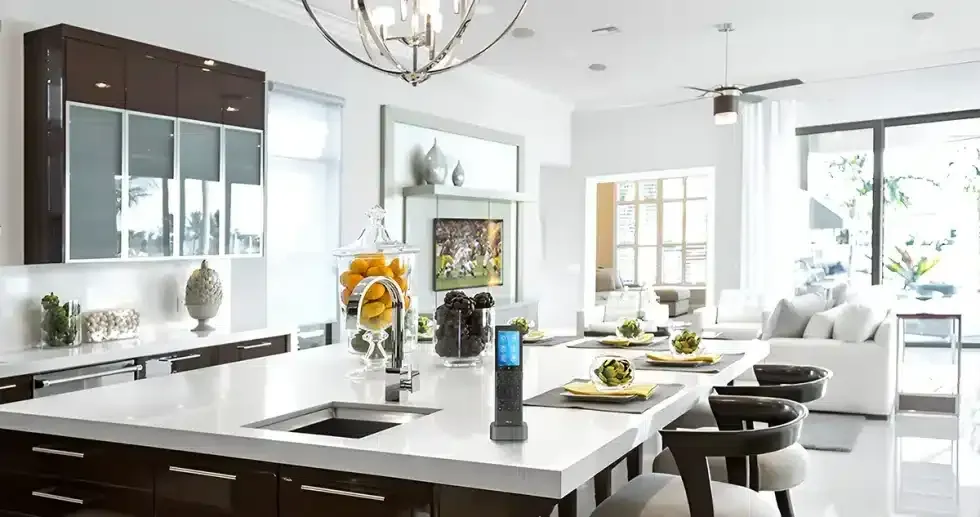 Modern kitchen with a large island, dark cabinets, white countertops, and seating.