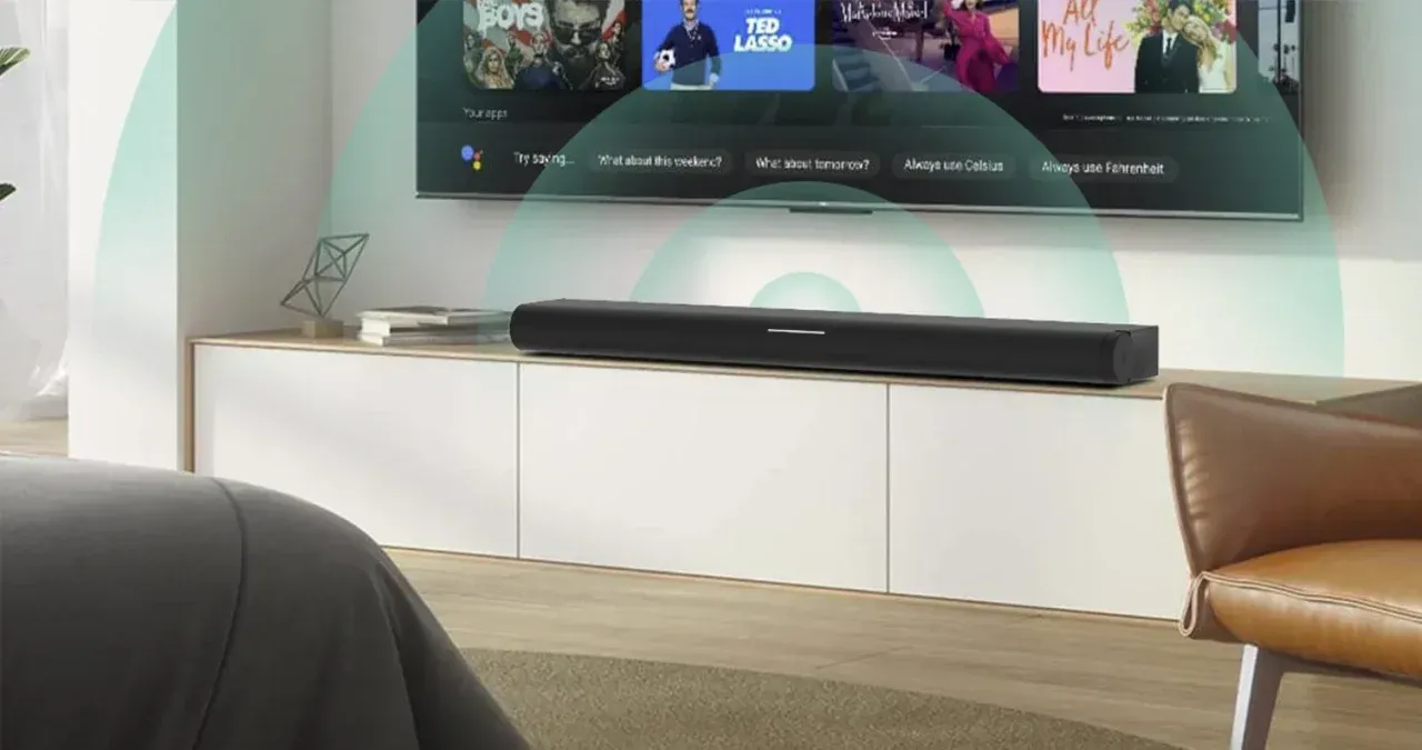 Sound bar on a white cabinet below a television; green sound wave graphics.