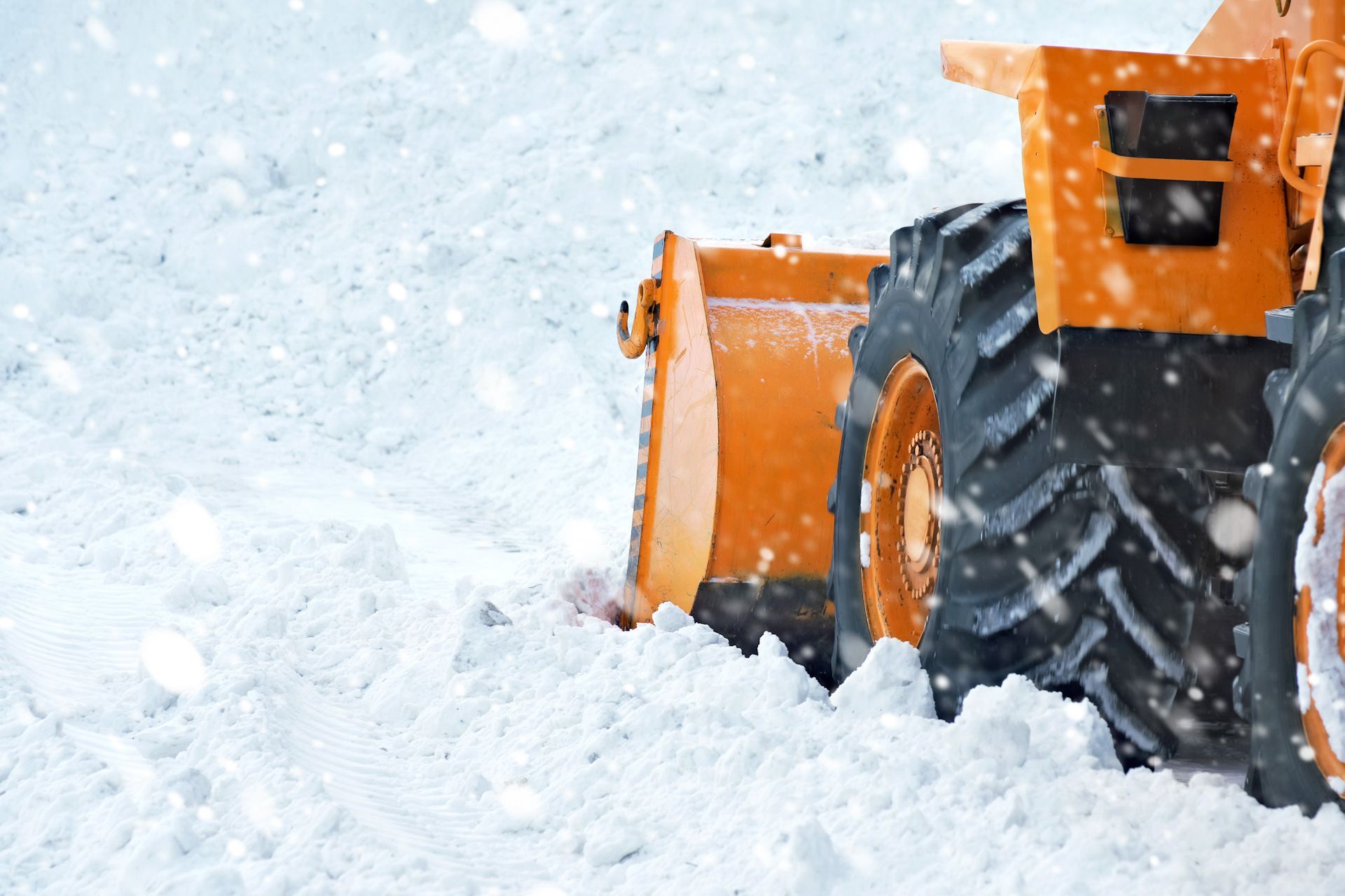A snow plow is clearing snow from a road.
