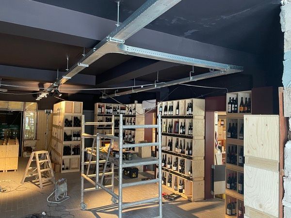 voorbeeld van een complete kabelgoot installatie hangend aan pendels. Alle bekabeling van Elektra, licht en internet/ cameras liggen netjes in de goot en de goot is afgemonteerd met een modulair systeem van winkelverlichting in drie groepen te schakelen.
