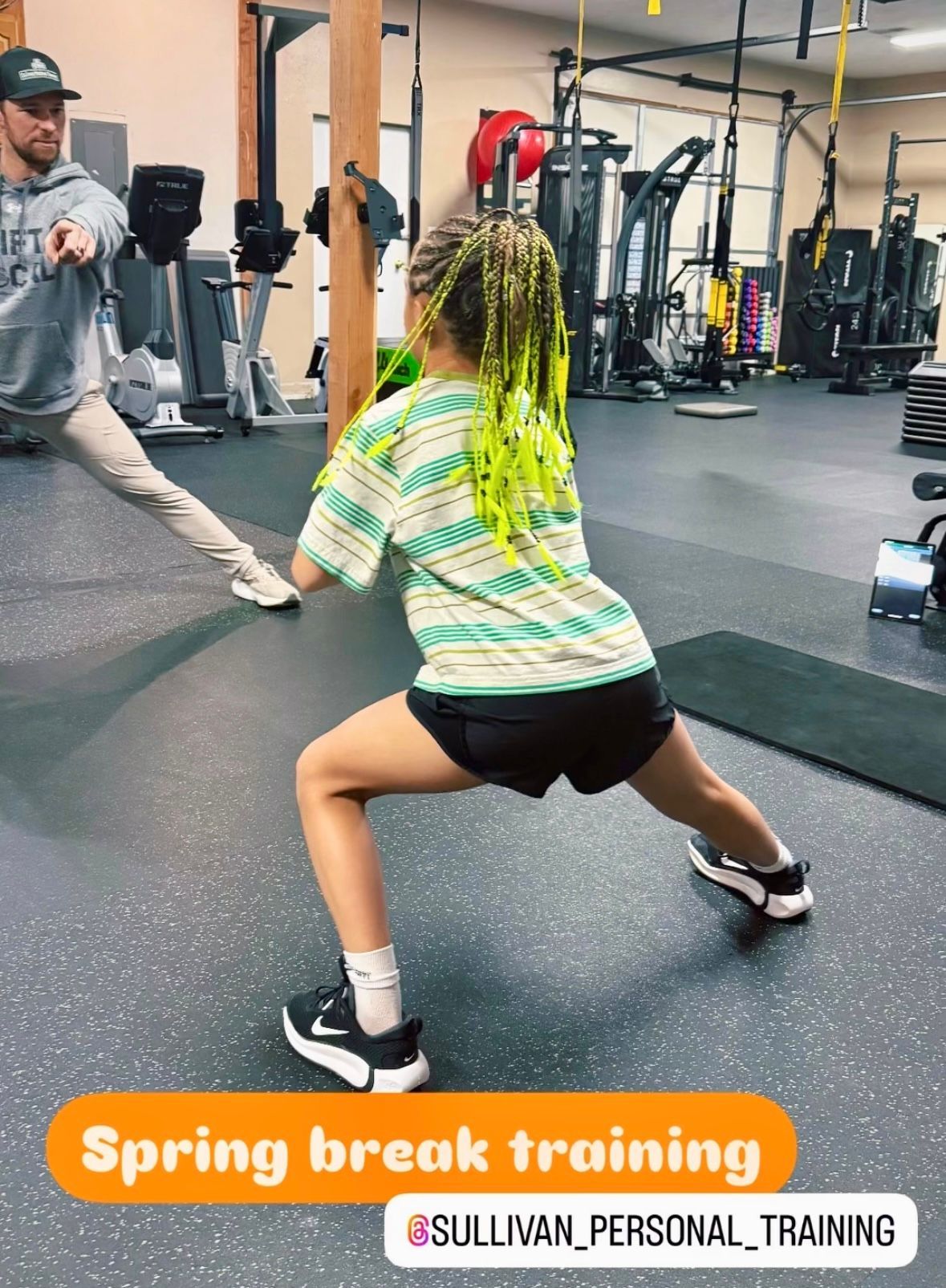 Child lunging during spring break training in a gym, coach demonstrating nearby
