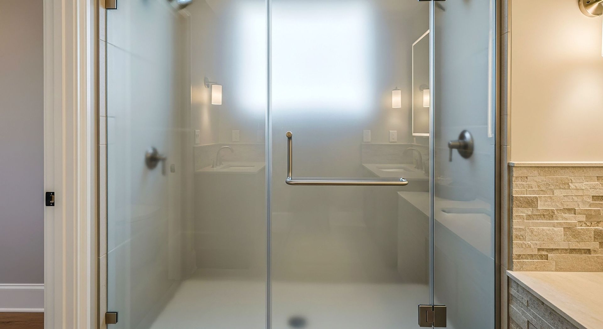 Modern walk-in shower with frosted glass doors and tiled walls