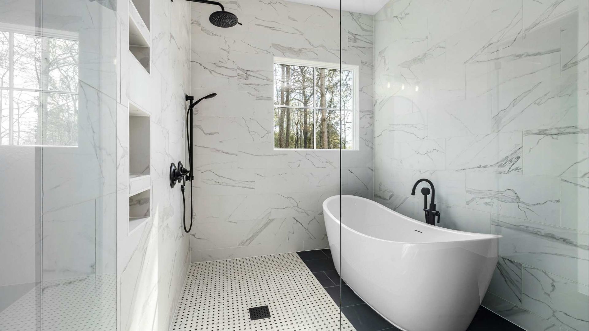 Bright white marble bathroom with walk-in shower, freestanding tub, black fixtures, and window light