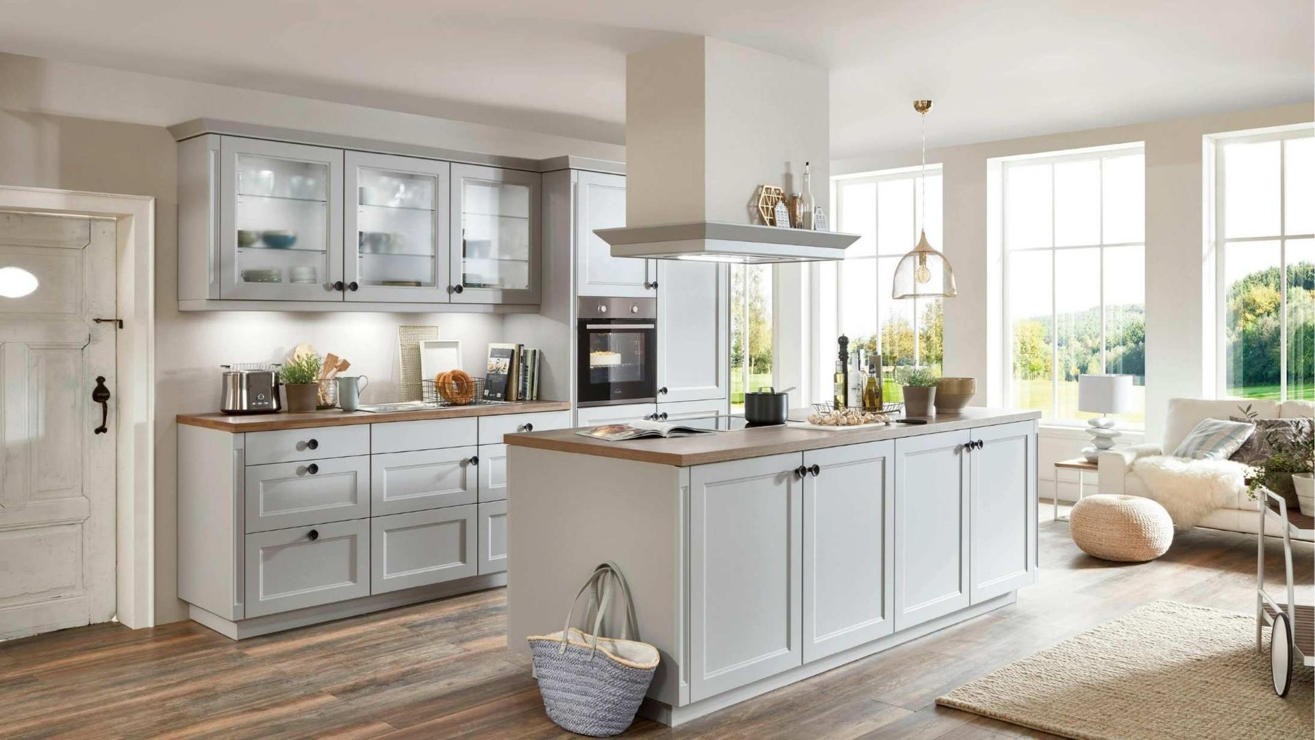 Bright white kitchen with island, cabinets, large windows, and cozy bench seating in sunlight