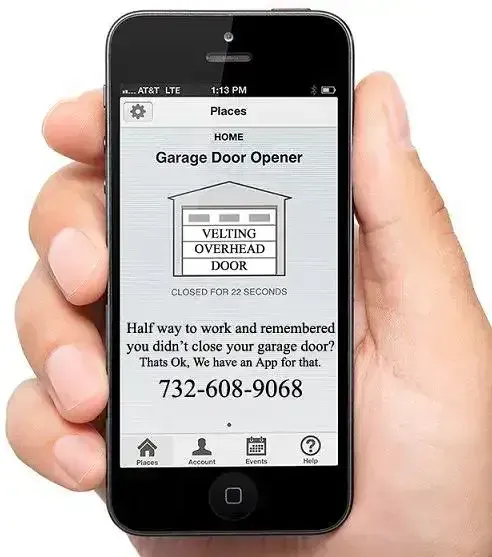 A person is holding a cell phone with a garage door opener app on it.
