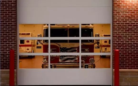 A fire truck is reflected in a white garage door