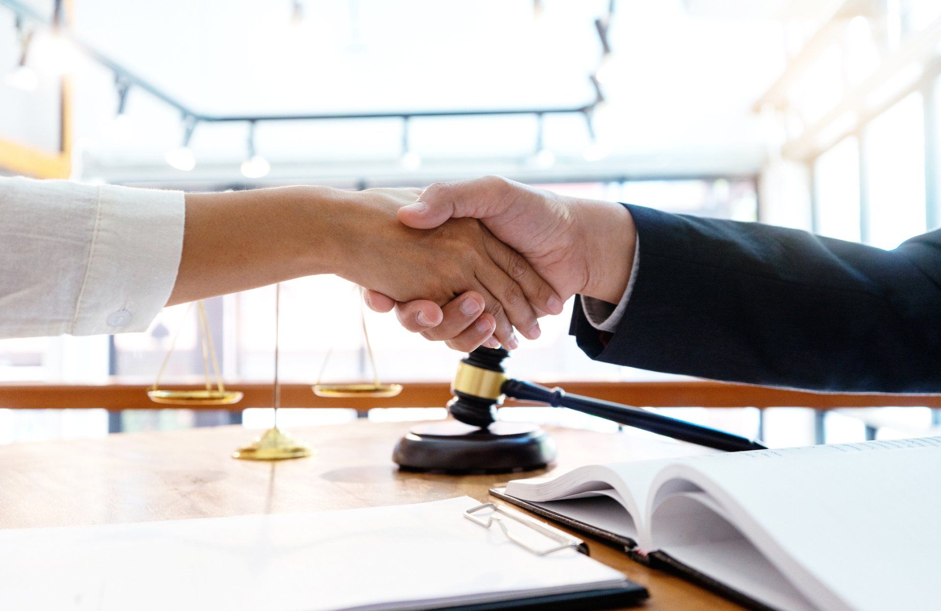 two people's hands on a table next to keys and a pen