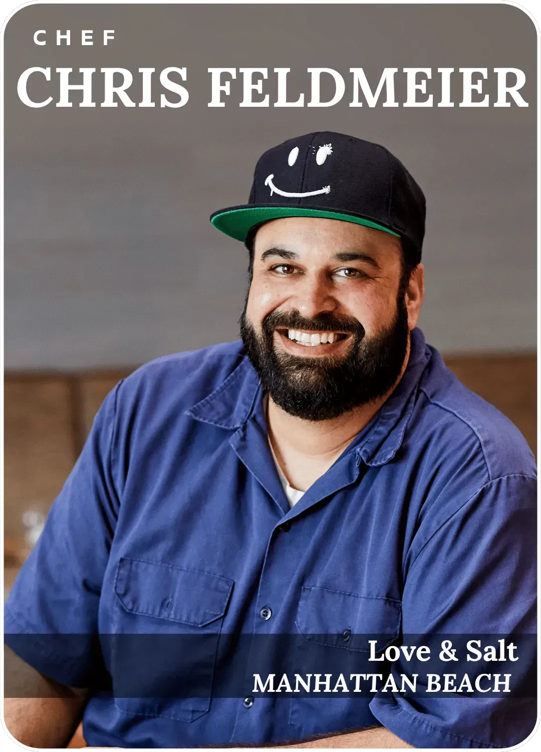 Chef Chris Feldmeier in blue shirt and black cap, smiling for Love & Salt Manhattan Beach portrait